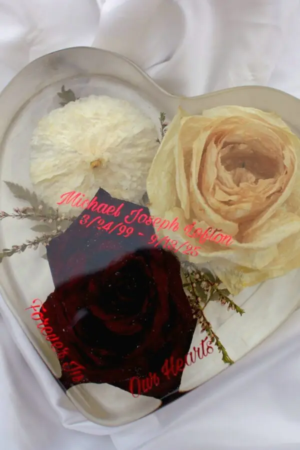 Heart-shaped resin memorial keepsake with preserved flowers.